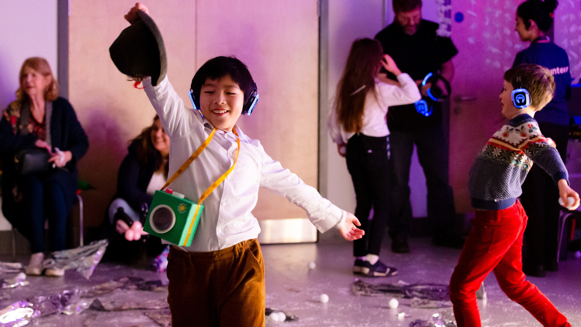 A group of children playing with wireless over the ear headphones on.