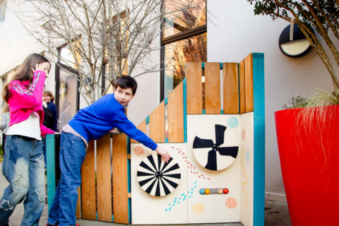 Children playing outside in the Polka play area.