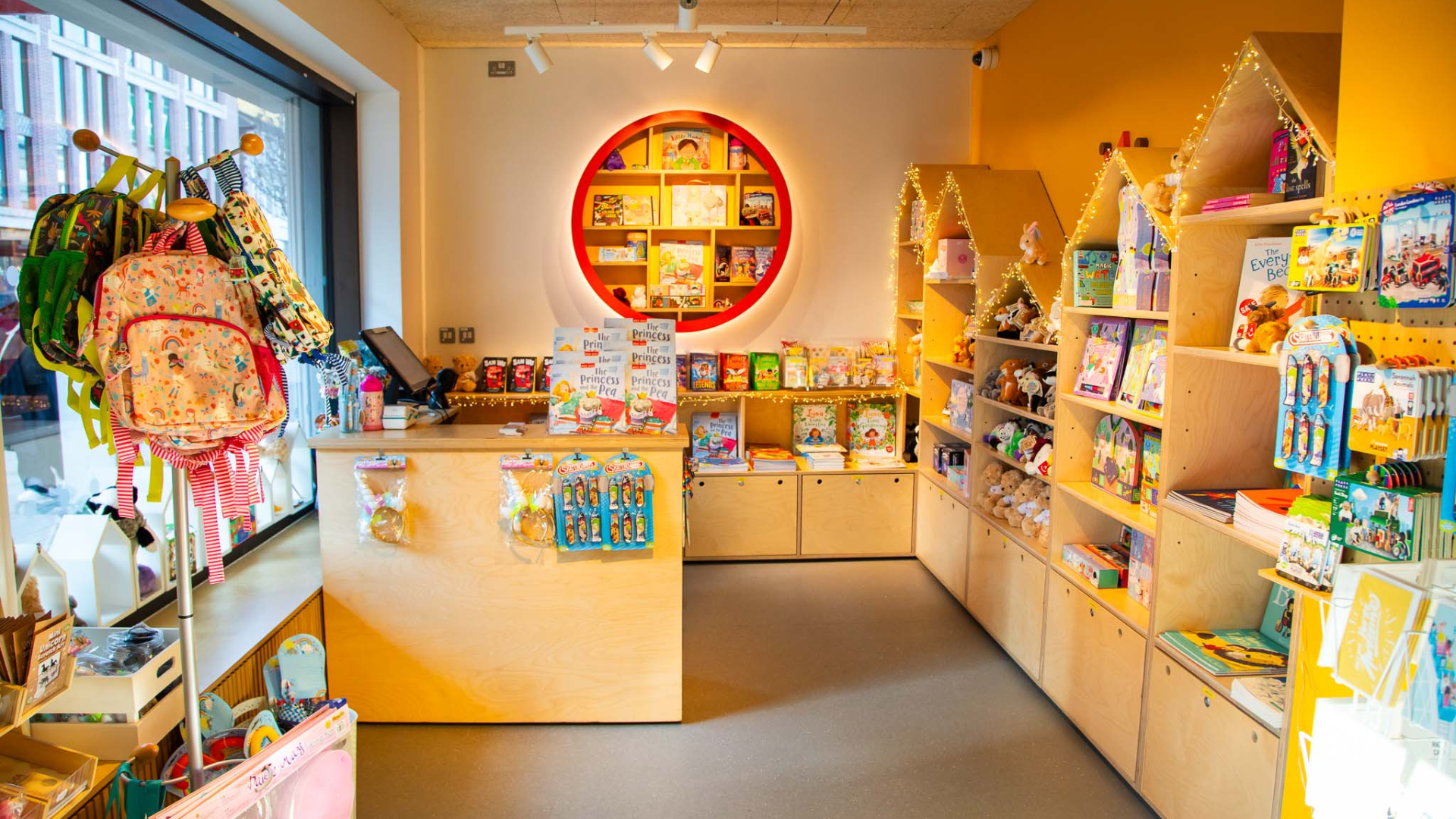 A long shot of the Polka theatre shop. The shelves are wooden and full of books and merchandise.