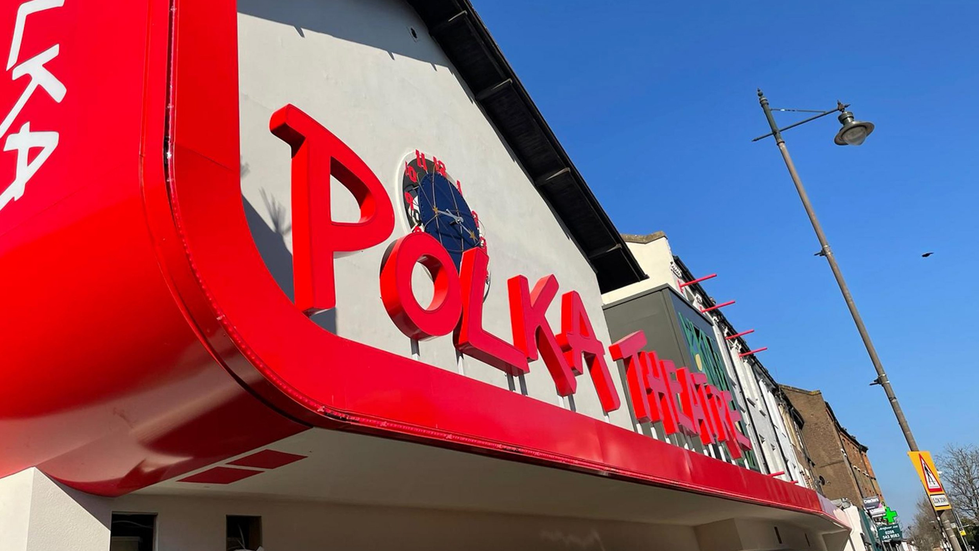 A close up of the Polka theatre sign outside the Polka building.